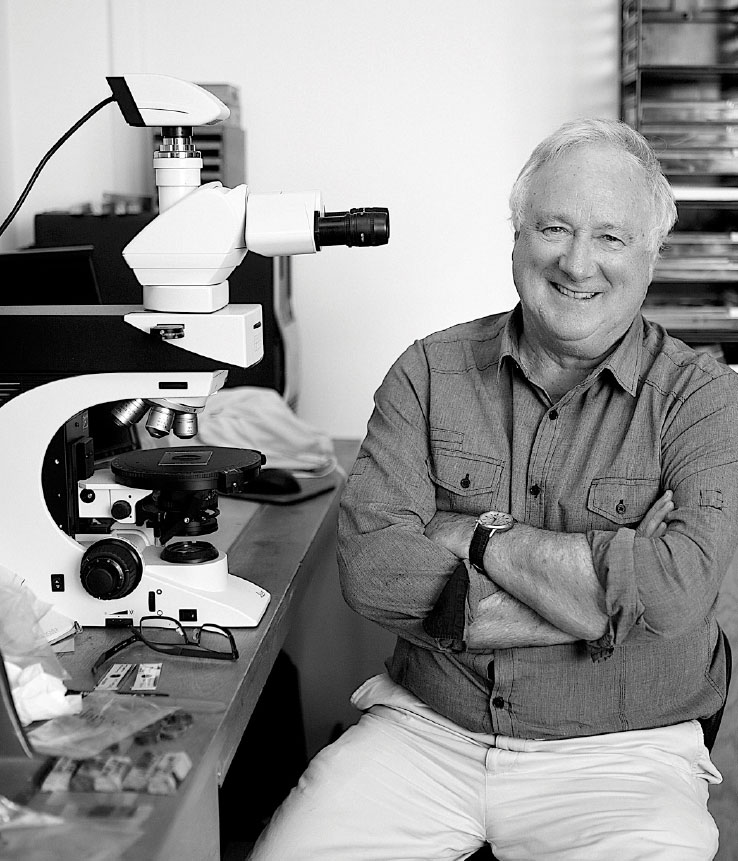 Black and white photograph of Distinguished Professor Ross Large in a laboratory.