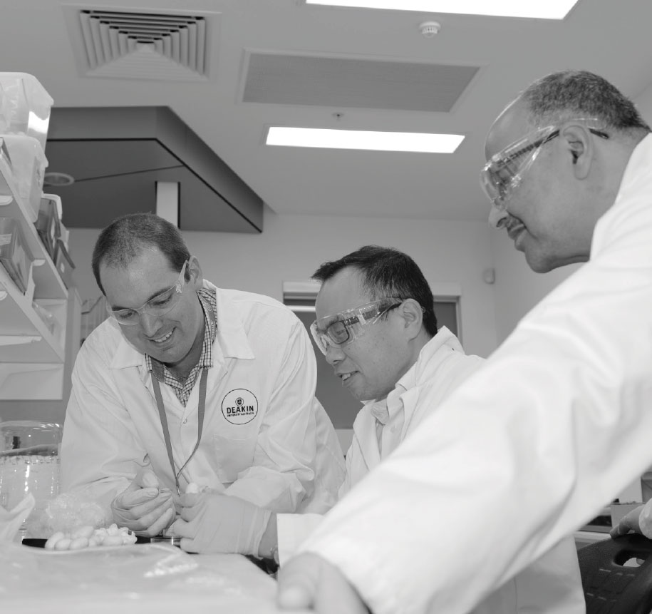 Black and white photograph of Deakin University team members working together.