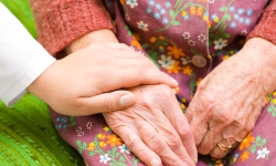 Young hand holding older woman's hand