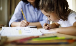 Mother helping daughter with homework.