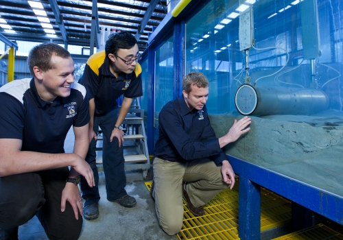 Researchers with subsea pipeline in the lab