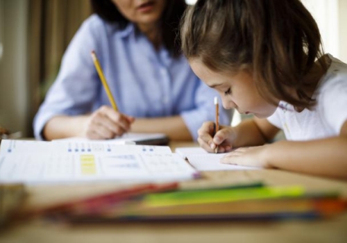 Mother helping daughter with homework.